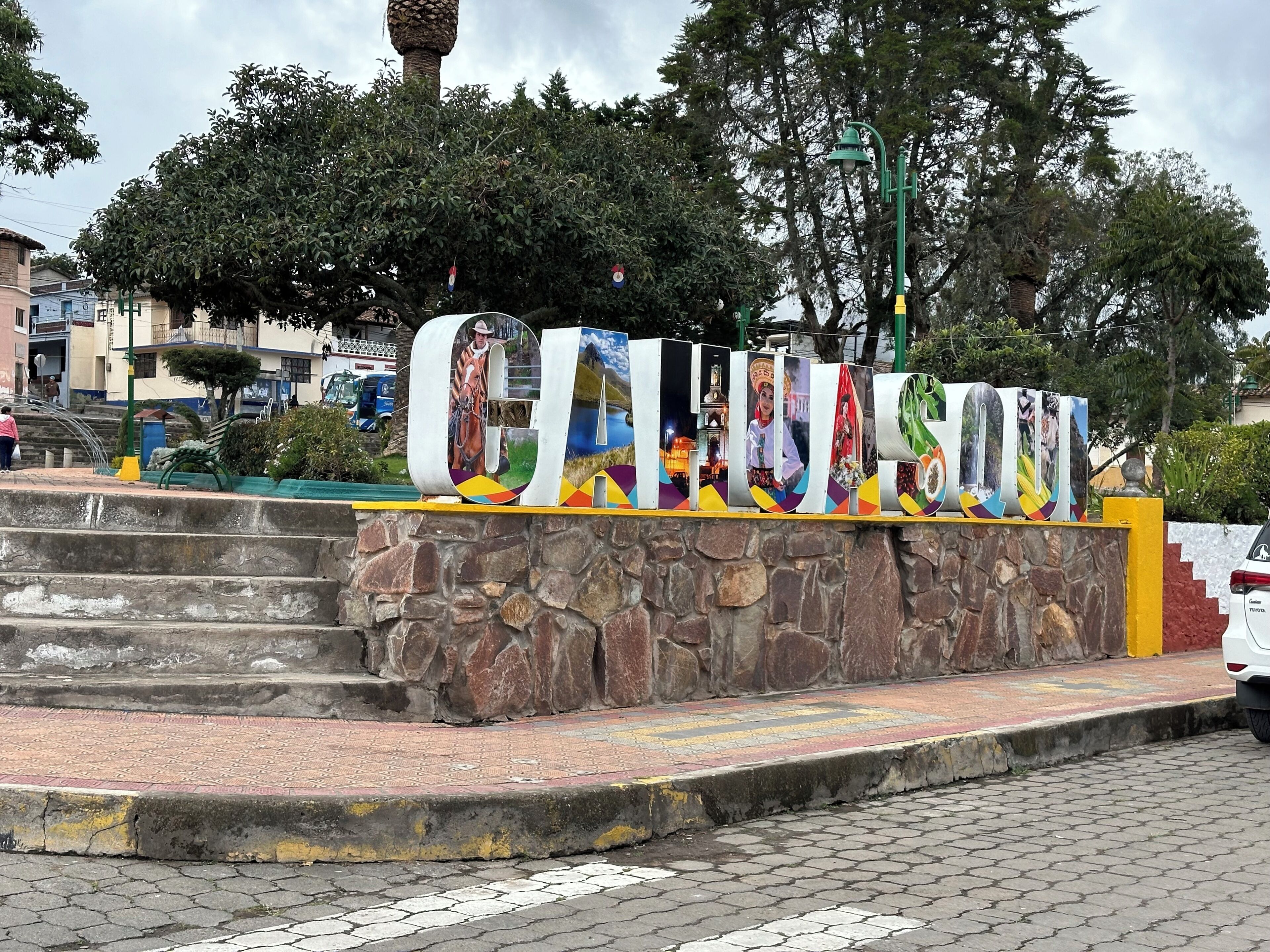A stone wall with a colorful sign featuring various cultural images.