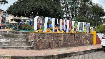 A stone wall with a colorful sign featuring various cultural images.
