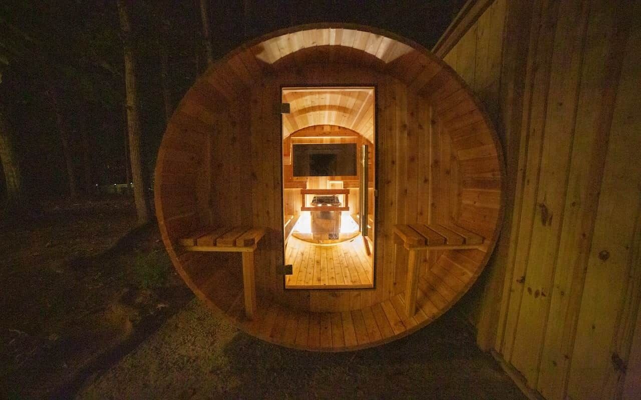 A wooden cylindrical structure with a bench and a small table in the center.