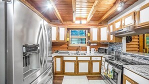 Una cocina moderna con armarios de madera, electrodomésticos de acero inoxidable y una isla central.