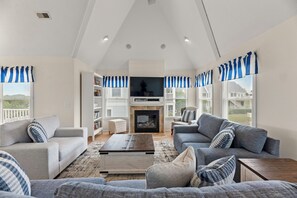 Ein Wohnzimmer mit Kamin, Sofas und Fernseher.