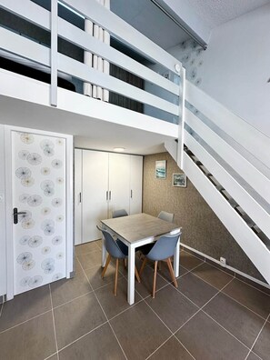 Un interno moderno con zona pranzo, scala e una porta decorata con un motivo a tarassaco.