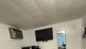 Un dormitorio con una cama, un aparador, un televisor y una mesita.