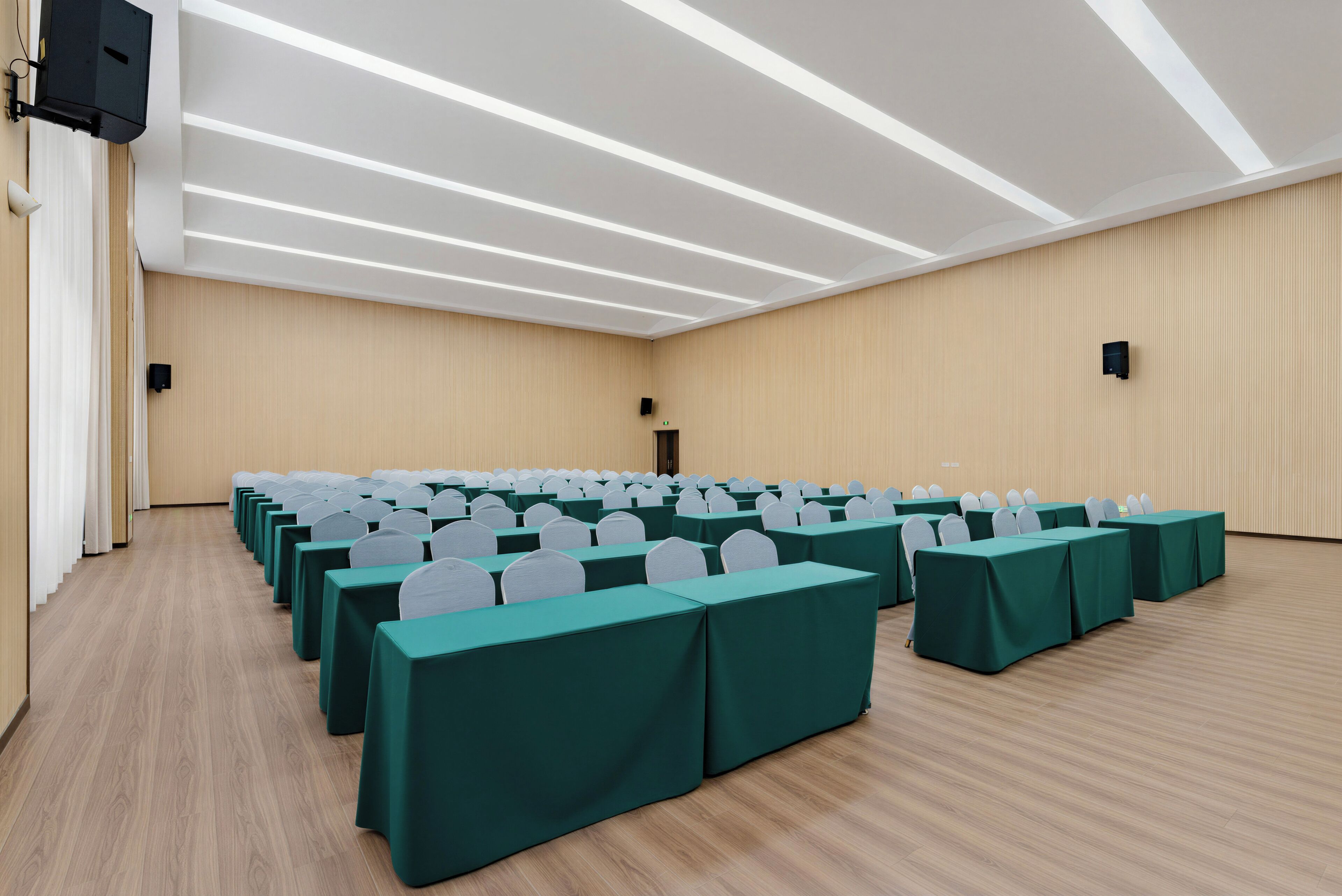 Uma sala de conferências com mesas, cadeiras dispostas em fileiras e um palanque.
