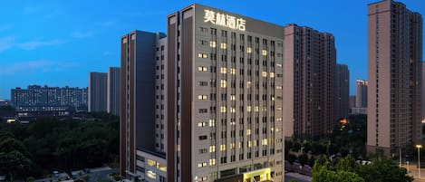 Un hotel moderno de gran altura, con fachada contemporánea, varios pisos y una entrada bien iluminada.