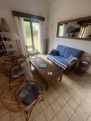 A living room with a sofa, chairs, a coffee table, and a bookshelf. - Charming, quiet family home for golf, beach and nature lovers (Moliets-et-Maa)