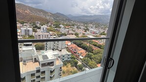 Blick vom Balkon auf eine Stadtansicht, einschließlich Gebäude und Berge in der Ferne.