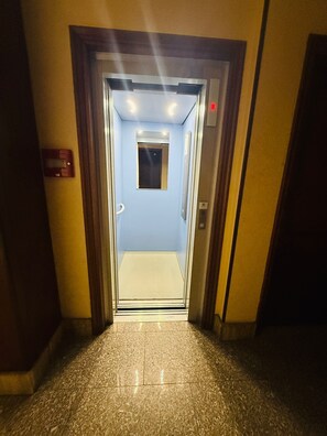 An elevator entrance with a light blue interior, a small window, and a control panel on the wall. - Terrazzino in centro/300mt dal Mare (Marina di Andora)