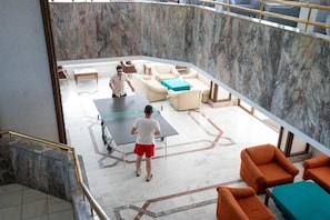 Amplio espacio interior con mesa de ping pong, asientos y suelo de mármol.