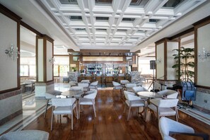 Un amplio bar con varias opciones de asientos y un diseño moderno en el techo.
