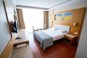 Ein Hotelzimmer mit Bett, Nachttisch, Stuhl und einem Bild an der Wand.