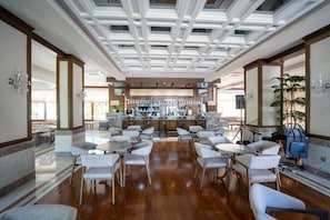 Amplia zona de bar con diversas opciones de asientos y una barra central.