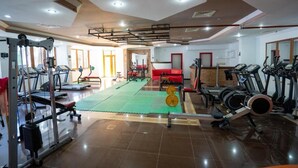 A gym with exercise equipment, a green mat, and a red couch. - CASA SOLADA CUNDA RESORT & SPA (Ayvalık)