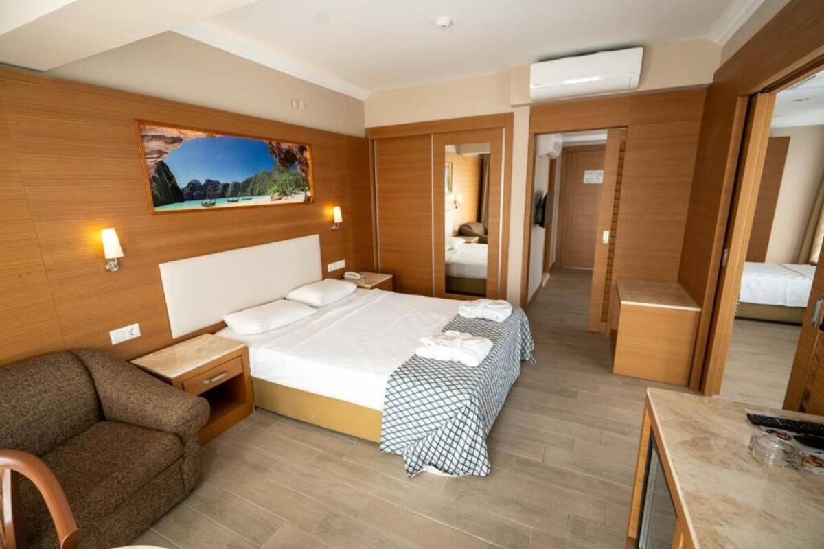 Una habitación de hotel con una cama grande, un sofá, un escritorio y un espejo.