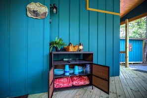 Een kamer in teal met een rieten plank waarop borden, bekers en een pot staan.
