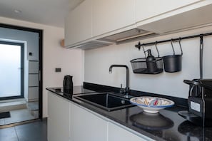 Eine moderne Küche mit schwarzem Arbeitsplatz, einer Spüle und einer Kaffeemaschine.