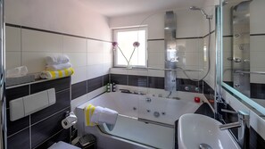 Une salle de bain moderne avec une baignoire, un lavabo et une douche.