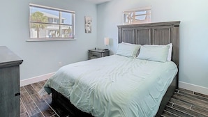 A bedroom with a bed, a ceiling fan, a nightstand, a window, and a dresser. -  Waterfront,Private Beach • Dock • Kayaks, Grill ,Firepit,SUN,HeatedPool,3 Beds (Hernando Beach)