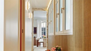 Ein Flur mit einer Holztür, einem weißen Stuhl und einem Blumenstrauß.