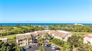 Ein Resort mit Meerblick, mehreren Gebäuden und einem Parkplatz.