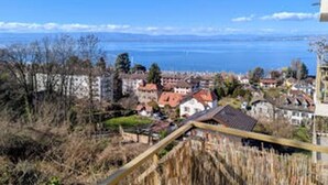 A coastal town with buildings, a wooden bridge, and a clear view of the sea. - Charming apartment, lake view - 2 guests (Neuvecelle)
