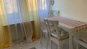 A dining area with a table and chairs, a heart-shaped decoration on the wall, and a rug with text. - Vacation apartment/ accommodation for 5-6 persons in Bodenwerder (Bodenwerder)