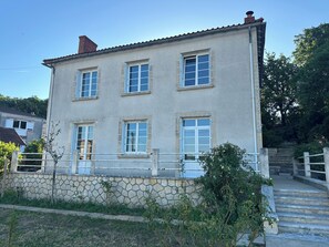 A two-story building with a stone facade, multiple windows, and a staircase leading to the entrance. - Maison Cœur de Famille - Between town and country (Chauvigny)
