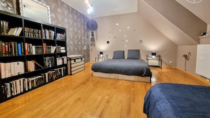 A bedroom with a loft bed, a bookshelf, a dreamcatcher, and a radiator.