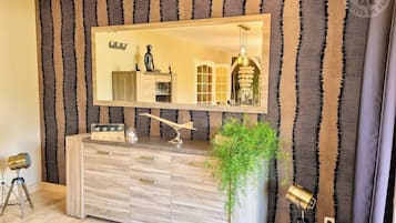Une salle de bain moderne avec un grand miroir, un meuble-lavabo en bois et une plante en pot.