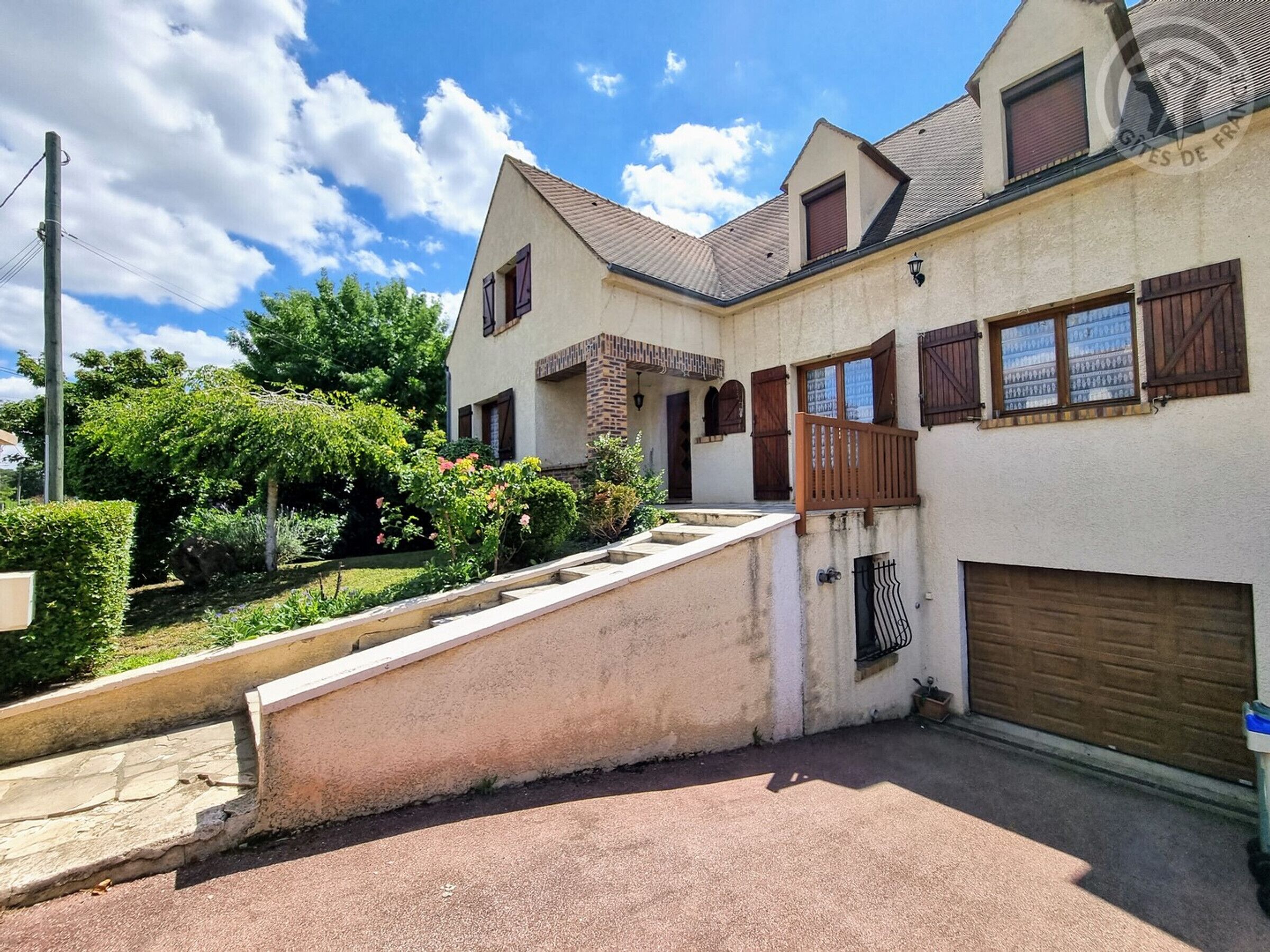 Een tweelaags huis met voortuin, oprit en garage.