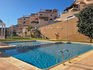 Ein Swimmingpool mit einer klaren, blauen Wasseroberfläche, umgeben von einer gefliesten Terrasse.