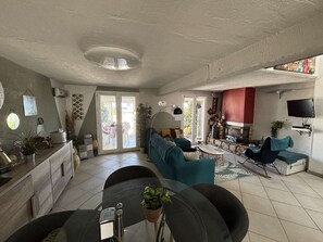 Ein geräumiger Wohnbereich mit Sofa, Esstisch und Küchenzeile.