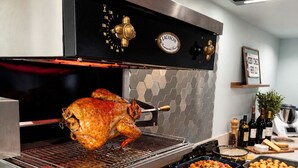 Une cuisine équipée d’un rôtissoir suspendu, d’une cuisinière et de divers ustensiles de cuisine.