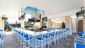 A spacious outdoor bar area with multiple seating arrangements and flat-screen TVs mounted on the ceiling. - Windsor Island 5BR Home Near Disney (Davenport)