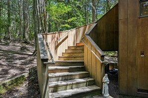 Eine Holztreppe führt zu einer Hütte im Wald.