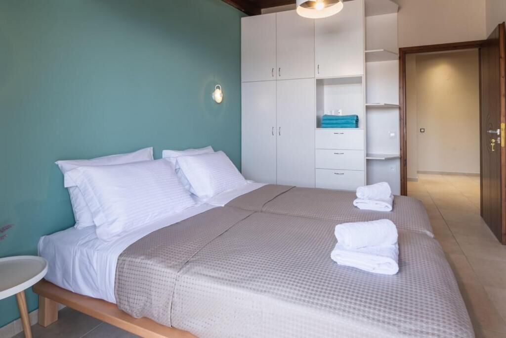Un dormitorio con cama, mesita de noche, armario y luz empotrada.