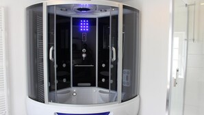 Ett modernt, avskilt massagerum med en kontrollpanel och en massagestol.