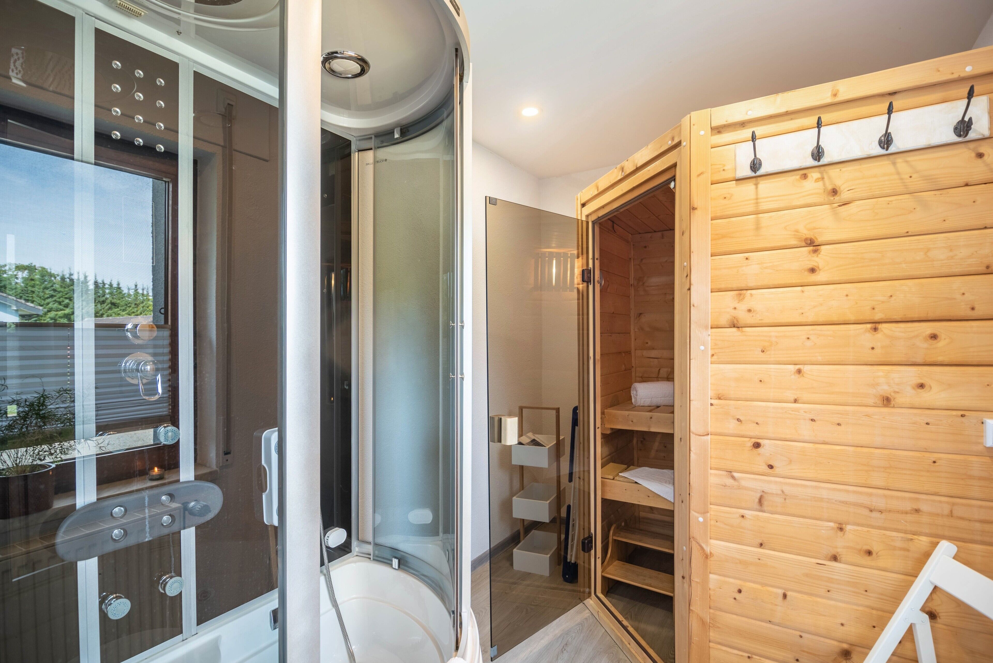 Ein modernes Badezimmer mit Duschkabine aus Glas, einem Holzwaschtisch und einer integrierten Regaleinheit.