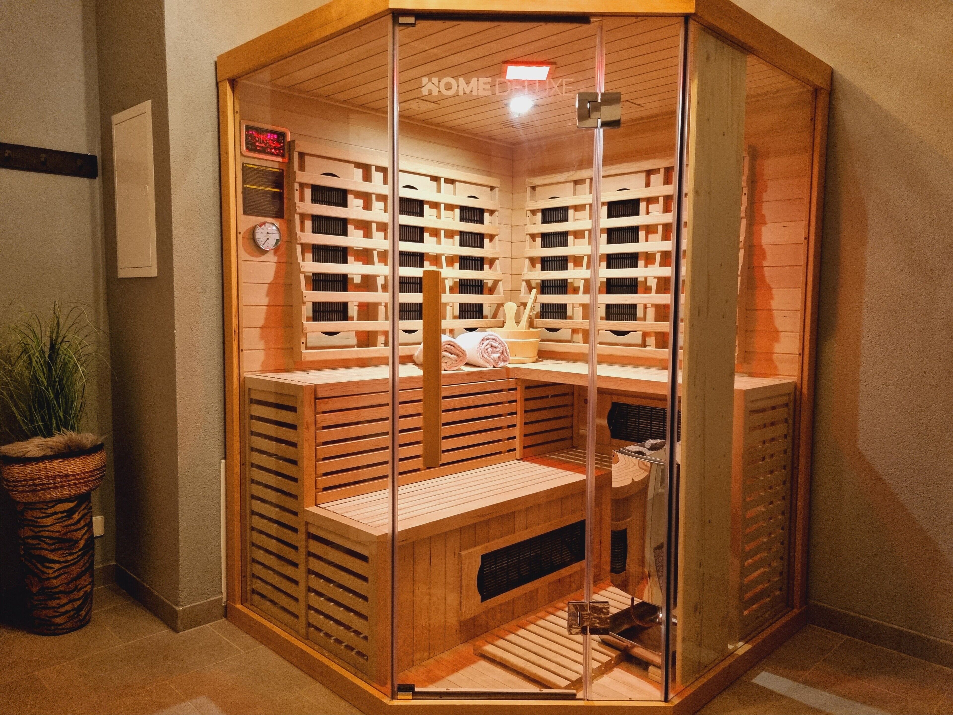 A sauna room with wooden benches and a glass partition.
