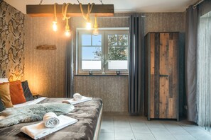 Ein Schlafzimmer mit einem Bett, einem Fenster und einem Holzschrank.
