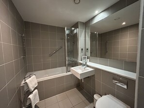 Ein modernes Badezimmer mit Badewanne, Dusche, Toilette und Waschbecken.