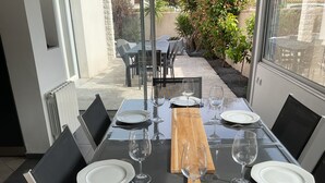 A dining table set for six with chairs, plates, wine glasses, and cutlery. - Villa with pool Between sea and nature (Lattes)