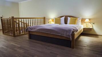 Un dormitorio con una cama de madera, una mesita de noche con una lámpara y un portón de madera.