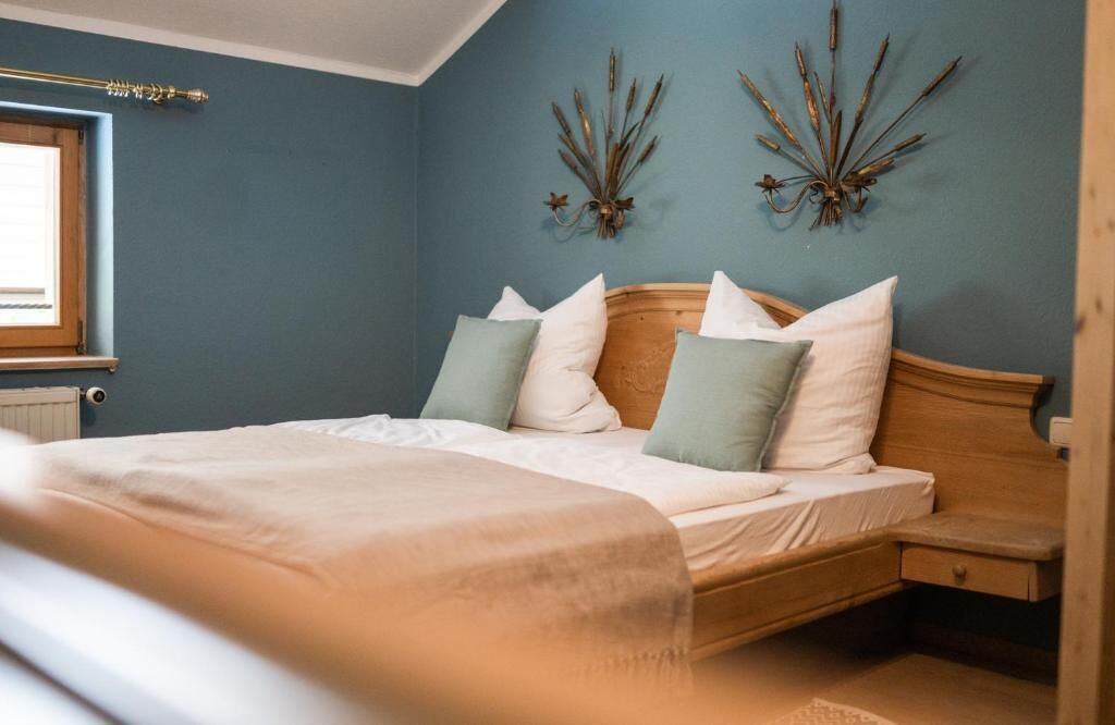 A bedroom with a bed, bedside table, and wall decor.
