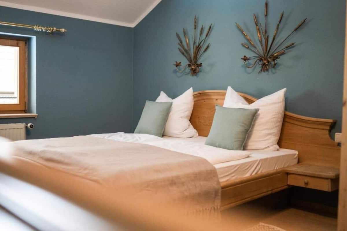 Un dormitorio con cama, mesita de noche y decoración en la pared.