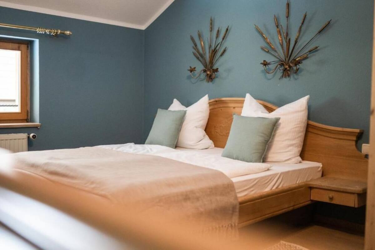 A bedroom with a bed, bedside table, and wall decor.