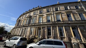 A historic building with classical architecture, featuring multiple windows and a prominent entrance. - Crown Circus Three Bedroom Apartment (Hillhead)