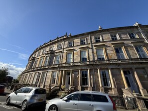 Ein historisches Gebäude mit klassischer Architektur, das zahlreiche Fenster und einen markanten Eingang aufweist.