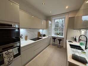 Eine moderne Küche mit Einbauofen, Spüle und Fenster.