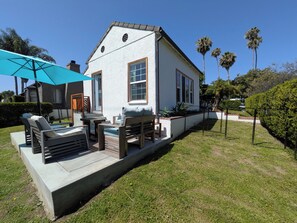 A house with a patio, outdoor furniture, and a blue umbrella. - Pet-friendly Retreat in LA's Best Neighborhood (Los Angeles)
